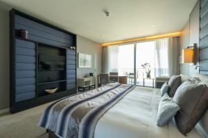 a bedroom with a large bed and a television at InterContinental Cascais-Estoril by IHG in Estoril