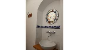 a bathroom with a toilet and a plate on the wall at La Vieja Esquina in Cachí +19 photos