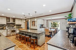 a kitchen with a large island with bar stools at 4527 Whisper Way in Pensacola