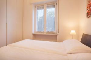 a bedroom with two white beds and a window at Villa Cesarina-Vista lago totale in Brenzone sul Garda