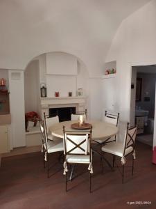 モンテ・サンタンジェロにあるCasa Gatta - Affitti Brevi Italiaのダイニングルーム(テーブル、椅子、暖炉付)