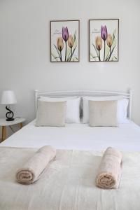 a bedroom with a white bed with two towels on it at Didis Place Nafplio in Nafplio