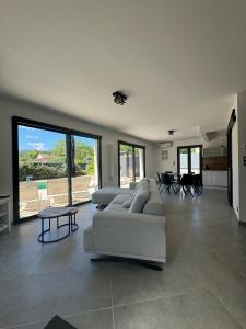 a living room with couches and tables and windows at Modern Villa in Sampzon
