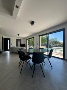 a dining room with a glass table and chairs at Modern Villa in Sampzon