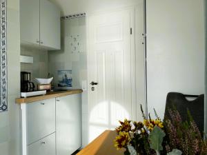 a kitchen with a table and a white door at Huus Lüttenblick Whg Amrumblick in Südstrand