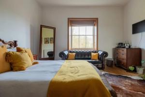 a bedroom with a large bed and a couch at Walltree House in Brackley