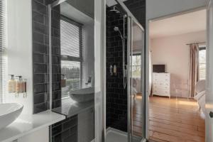 a bathroom with two sinks and a glass shower at Walltree House in Brackley