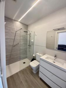 a bathroom with a shower and a toilet and a sink at Apartamentos el puente in La Abadilla +42 photos