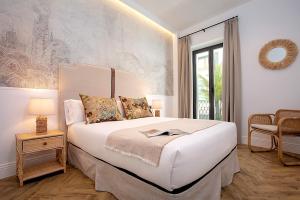 a white bedroom with a bed and a window at Genteel Home Casa Lagar III in Seville