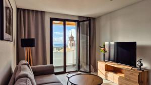 Una sala de estar con un sofá y un televisor de pantalla plana. en GuestReady - Relax and Recharge in Funchal, en Funchal