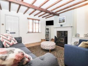 a living room with a couch and a fireplace at Chestnut Cottage in Wetwang