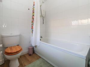 a bathroom with a toilet and a bath tub with a towel at Chestnut Cottage in Wetwang +12 photos