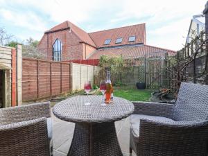 a table with two glasses of wine on a patio at Chestnut Cottage in Wetwang