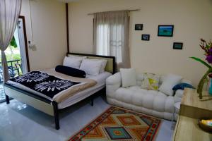 a bedroom with a bed and a couch in it at Tiny Boutique House Koh Kood in Ban Lak Uan