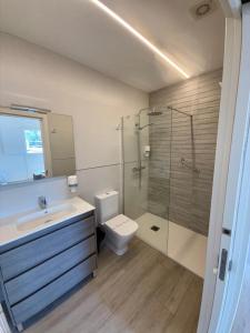 Un baño con lavabo, inodoro y ducha. en Apartamentos el puente, en La Abadilla
