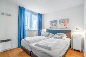 a bedroom with a large bed with blue curtains at Appartementencomplex Juliana 52 in De Koog