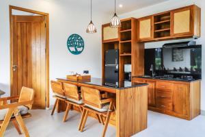 BlahbatuにあるMarvella Villa - Rare Finding near Ubud Centerのキッチン(木製キャビネット付)、島(椅子付)