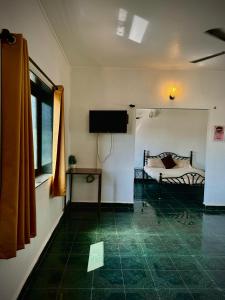 a room with a bed and a flat screen tv at 1BHK Apartment at Honeydew 8 by Goaround Homes in Vagator