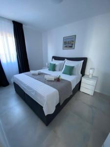 a bedroom with a large bed with green and white pillows at Donatella Apartment 2 in Podstrana +30 photos