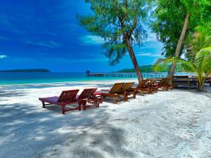 a row of lounge chairs on a beach at Kohrong Central Beach in Koh Rong Island