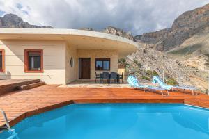 a house with a swimming pool and two chairs at Sea View Villa Emmanuela, By IdealStay Experience in Paránimfoi