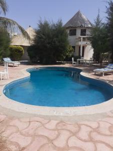 a large swimming pool in front of a house at Kernico in Mbour