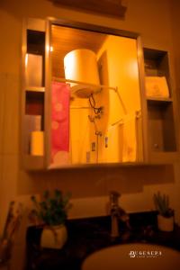 a mirror above a bathroom sink with a lamp at Bugesera Lake Resort in Karizinge +52 photos