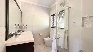 a white bathroom with a sink and a shower at 727 Church in Clarens