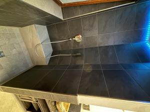 a bathroom with a shower with a blue tiled wall at Ferienwohnung HUGO in Penzberg
