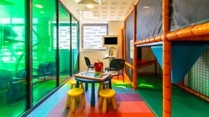 a room with a table and stools and a bunk bed at Holiday Inn Dijon Toison D'or by IHG in Dijon +149 photos