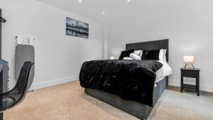 a bedroom with a bed with a black blanket at JD Serviced Apartments East Croydon in Croydon
