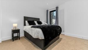 a bedroom with a bed with a black blanket on it at JD Serviced Apartments East Croydon in Croydon