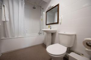 a white bathroom with a toilet and a sink at Cocked Hat by Greene King Inns in Coventry