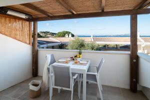 a white table and chairs on a balcony with a view at Appartamento Domo de oro in Baja Sardinia