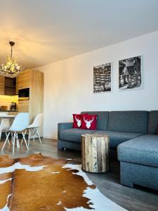 a living room with a blue couch and a table at Apartment Happy Holiday - neu renoviert, gemütlich in ruhiger Lage in Schliersee