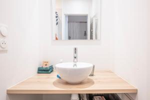 a bathroom with a white bowl sink on a wooden counter at Le Cœur de Pau in Pau