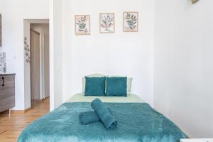 a bedroom with a bed with blue pillows on it at Le Cœur de Pau in Pau +4 photos