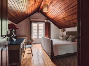 um quarto com uma cama, uma escrivaninha e uma janela em Quinta Dos Anjos em Santarém