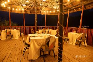 a restaurant with white tables and chairs and lights at Bugesera Lake Resort in Karizinge