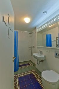 a bathroom with a toilet and a sink and a mirror at Vila Balta Balta in Nida
