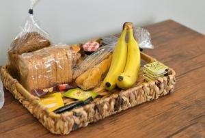 a basket filled with bread and bananas on a table at Krya Suites in Livadeia