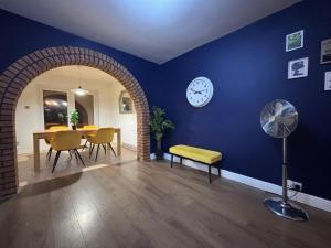 a dining room with a table and a clock on the wall at The Grand 7 in Wyken