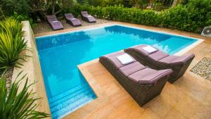 a swimming pool with two lounge chairs next to it at Villa Nia with private pool in Trogir