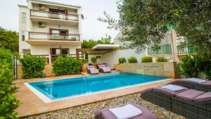 a villa with a swimming pool in front of a building at Villa Nia with private pool in Trogir