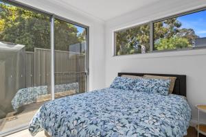 a bedroom with a bed and two large windows at Prospect High Street House in Prospect