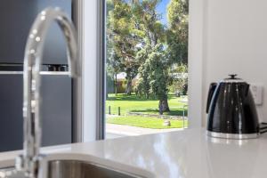 a kitchen sink with a window looking out at a park at Prospect High Street House in Prospect