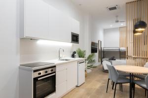 a kitchen with a sink and a table with chairs at Luxury Apartments Oceanografic in Valencia