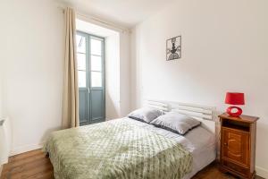 une chambre avec un lit et une fenêtre dans l'établissement Le Doux Séjour, à Pau
