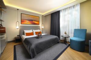 a hotel room with a bed and a blue chair at The Capital Hotel in Istanbul +18 photos