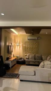 a living room with a couch and a tv at Luxury homes in Hyderabad +9 photos